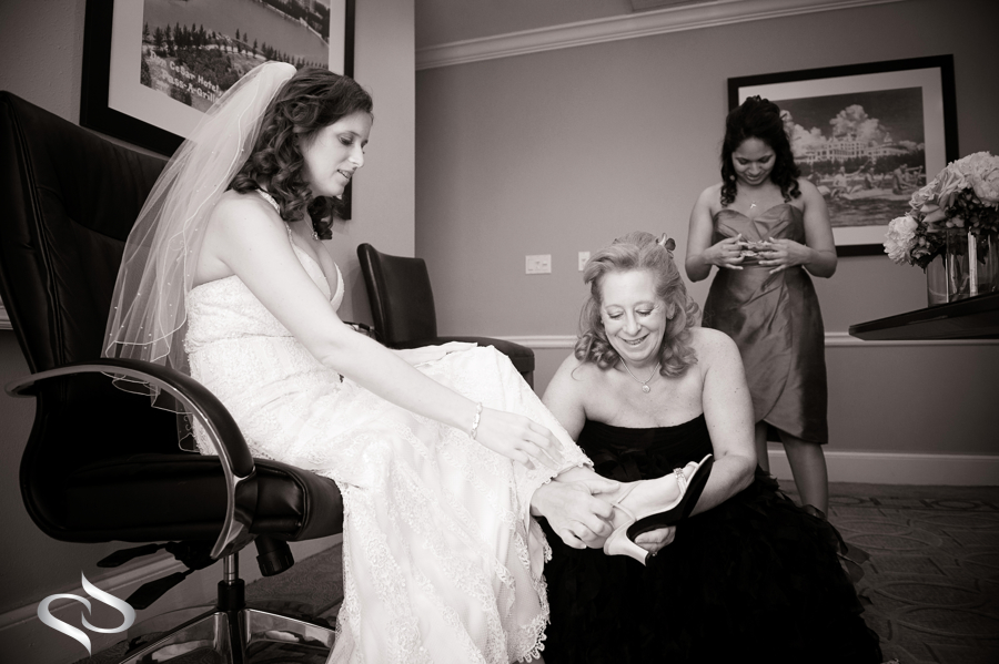 Mother putting on brides shoes