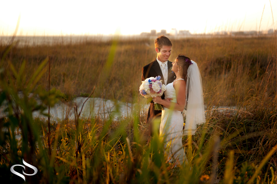 Bride in groom in sea oats grass