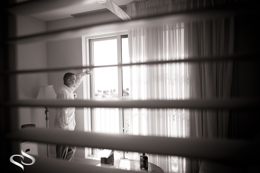 Groom looking out window at the Little Harbor Resort wedding