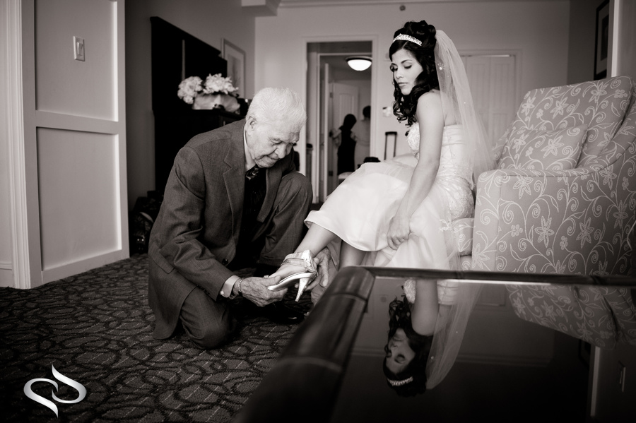 Grandfather helping bride with shoes