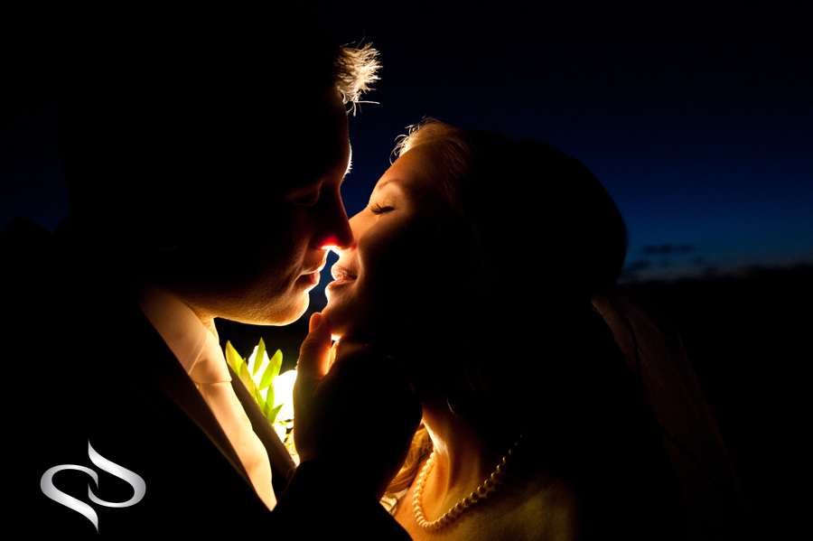 Bride and groom wedding kiss at night on the beach