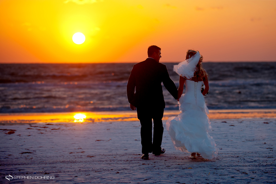 bride and groom walk into the sunset
